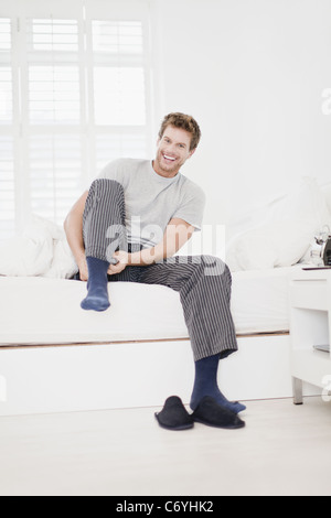 Mettre des chaussettes homme au lit Banque D'Images