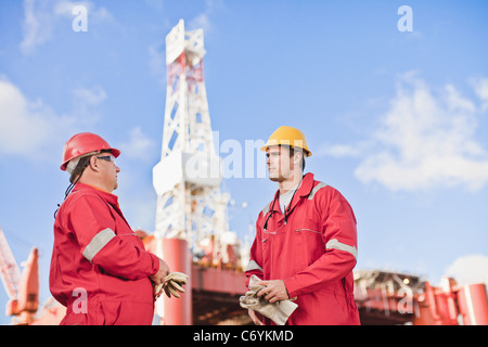 Workers talking sur plate-forme pétrolière Banque D'Images