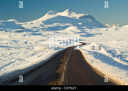 A837 route menant à travers la lande congelé en face de cul Mor (849 mètres), à au sud-ouest de Ledmore Junction. Banque D'Images