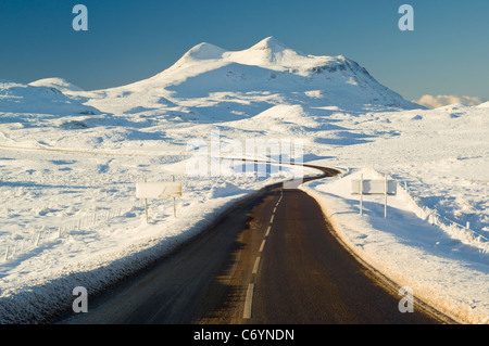 A837 route menant à travers la lande congelé en face de cul Mor (849 mètres), à au sud-ouest de Ledmore Junction. Banque D'Images