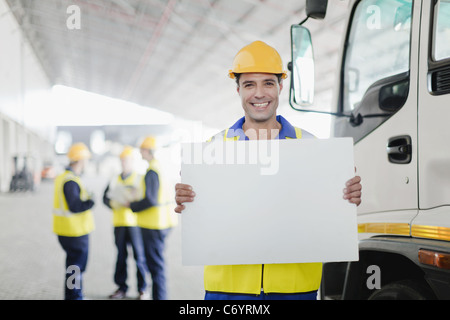 Worker holding blank card par camion Banque D'Images