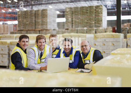 Les travailleurs utilisant un ordinateur portable dans l'entrepôt Banque D'Images
