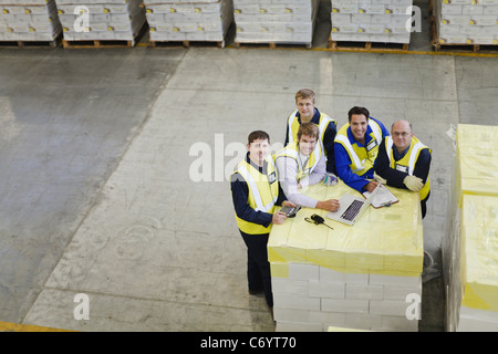 Les travailleurs utilisant un ordinateur portable dans l'entrepôt Banque D'Images