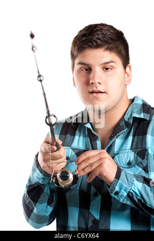 Un adolescent est surpris qu'il bobines dans un gros poisson. Isolated over white en studio. Banque D'Images