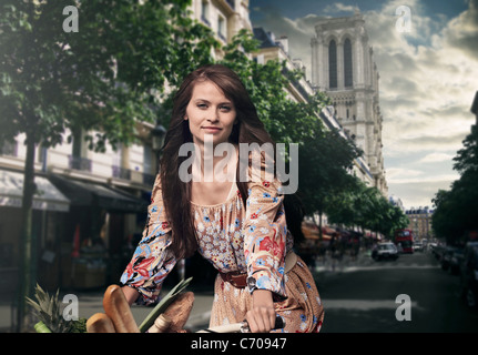 Woman riding bicycle in town Banque D'Images