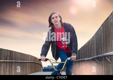 Boy riding bicycle sur tapis roulant Banque D'Images