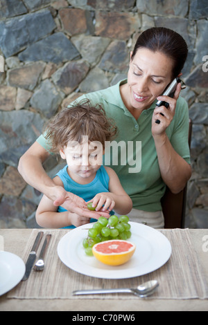 Woman eating breakfast avec fils Banque D'Images