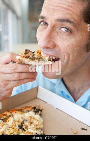 Close up of man eating pizza Banque D'Images