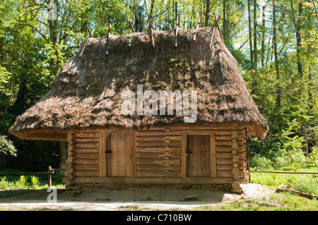 Un vieux, négligés, maison de bois est dans le village ukrainien. Chambre à partir de grumes en bois avec un toit de chaume. Banque D'Images