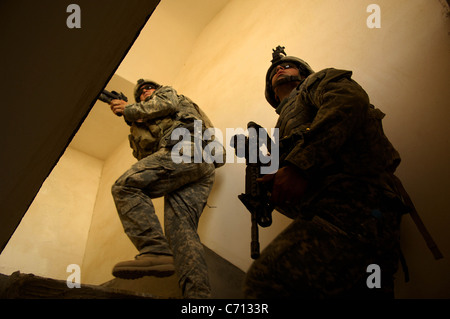 Monter un escalier soldats alors qu'ils s'effacer une chambre au cours d'une patrouille dans la région de Tall Afar, l'Iraq, le 18 août, 2006. Les soldats sont de la 1re Brigade Combat Team, 2e Bataillon, 37e régiment blindé, 1st Armored Division. Photo du DoD par le sergent. Jacob N. Bailey, U.S. Air Force. (Publié) Banque D'Images