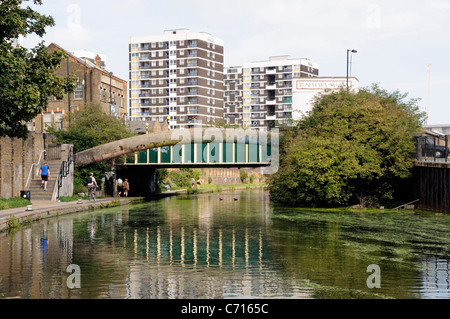 Pont sur le Regent's Canal avec les gens sur chemin de halage et appartements derrière Hackney London England UK Banque D'Images