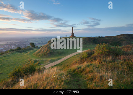 Couple regardant le coucher du soleil du War Memorial à Ham Hill Country Park. Le Somerset. L'Angleterre. UK. Banque D'Images