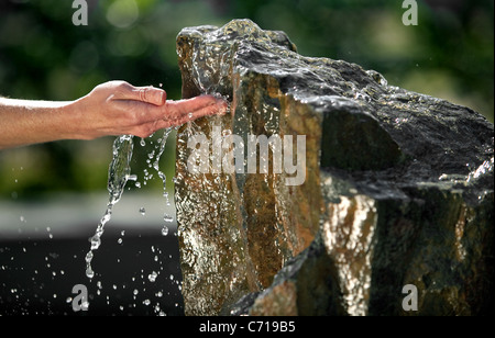 Verse l'eau sur un côté d'un rocher de la fontaine. Banque D'Images