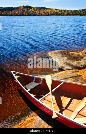 Red canoe sur rocky shore of Lake of Two Rivers, Ontario, Canada Banque D'Images