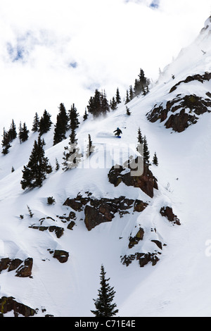 Un snowboarder sculpte une poudre tourner vers le bas une énorme montagne dans le Colorado. Banque D'Images