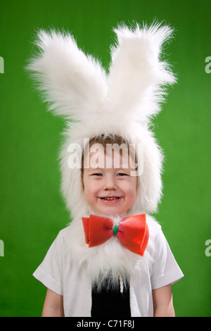 Garçon dans un costume de lapin duveteux blanc. Banque D'Images