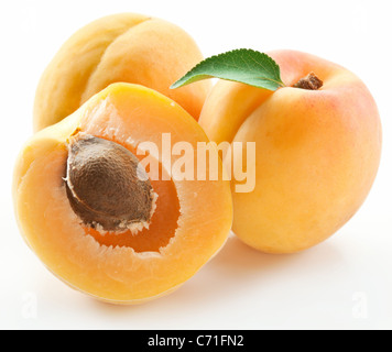 Les abricots avec des feuilles sur un fond blanc. Banque D'Images