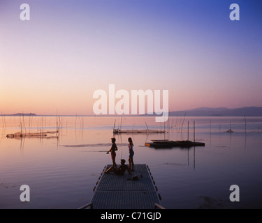 Les enfants de la pêche dans le Lac Trasimène au coucher du soleil, de l'Ombrie, Italie Banque D'Images