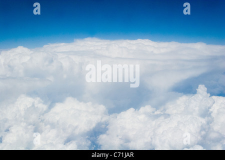 Au-dessus de nuages vus à travers la fenêtre de l'avion Banque D'Images