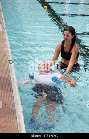 Les patients atteints de lésions cérébrales acquises ayant une déficience de participer à une thérapie de réadaptation aquatique avec les physiothérapeutes et leurs assistants. Banque D'Images