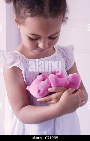 Little girl holding teddy bear affectueusement Banque D'Images