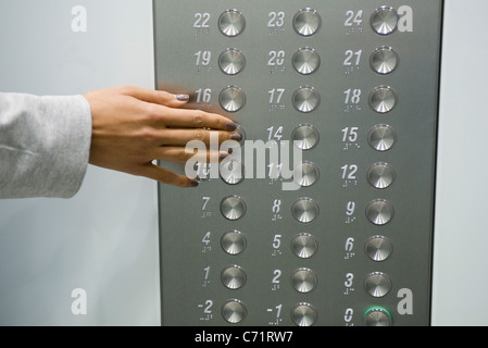 Woman's hand en appuyant sur bouton d'ascenseur, cropped Banque D'Images