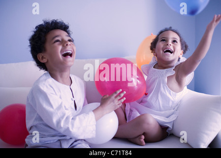 Les jeunes frère et sœur jouant avec des ballons Banque D'Images