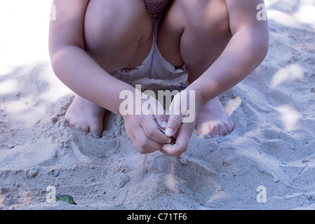 Petite fille jouant avec le sable, low section Banque D'Images