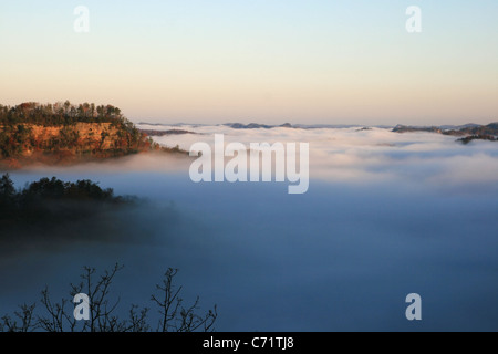 Une vallée remplie de brouillard à l'automne, juste après le lever du soleil avec des crêtes de lointain visible Banque D'Images