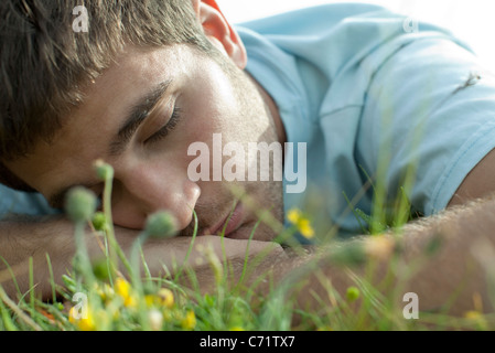 Homme sieste sur pré, close-up Banque D'Images