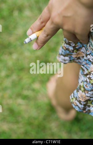 Woman's hand holding cigarette, cropped Banque D'Images