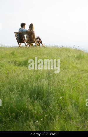 Couple assis sur des chaises sur le dessus de la colline à la vue à Banque D'Images