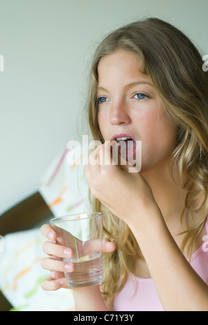 Jeune femme prenant un supplément alimentaire Banque D'Images