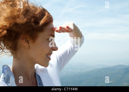 Woman looking at view, l'ombrage les yeux à part Banque D'Images