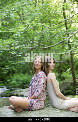 Female friends sitting on rock, portrait Banque D'Images
