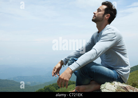 Man meditating on hilltop Banque D'Images