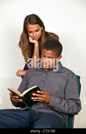 Californie multi ethnic diversité ethnique raciale African American boy et Hispanic girl lire la Bible ensemble. M. © Myrleen Pearson Banque D'Images