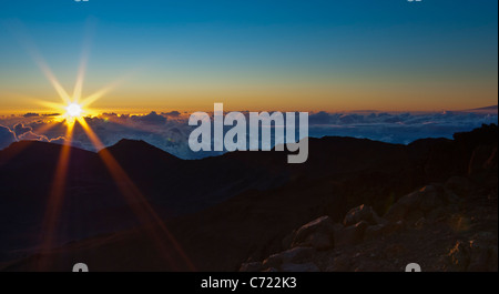 Lever du soleil au sommet du Mont Haleakala sur Maui Hawaii illuminant les nuages avec un bleu, orange et rouge ciel Banque D'Images