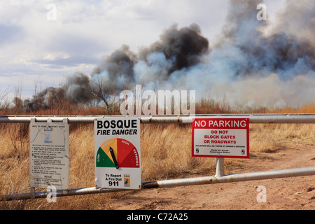 Un signe de danger d'incendie en milieu rural et la porte au Nouveau Mexique avec une traînée de feu à l'arrière-plan. Banque D'Images