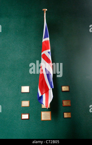 Un drapeau de l'Union sur un mur vert foncé avec des plaques en souvenir des soldats morts. Banque D'Images
