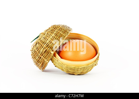 Oeuf de poule dans un petit panier isolated on white Banque D'Images