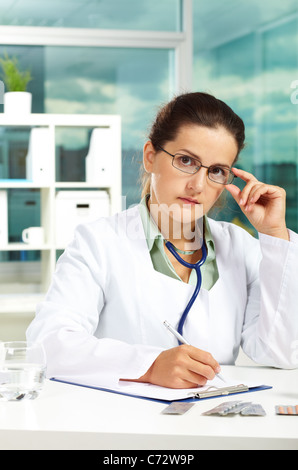 Portrait of female doctor looking at camera sur le lieu de travail Banque D'Images