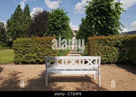 Banc de jardin blanc en face d'une rangée d'arbres, Borchers jardin, jardin privé à Goslar, Basse-Saxe, Allemagne Banque D'Images