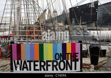 Sur le front de signer en face de Mercedes Tall Ship avec arrière-plan de réaménagement du salon Albert Dock Liverpool Banque D'Images