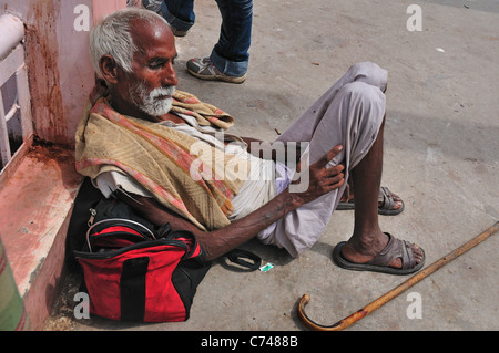 L'homme fatigué pèlerinage reposant à Har Ki Pairi ghat par le Gange. Banque D'Images