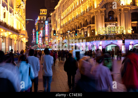 Les piétons à marcher la nuit passé stocke sur Nanjing Road, Shanghai, Chine Banque D'Images