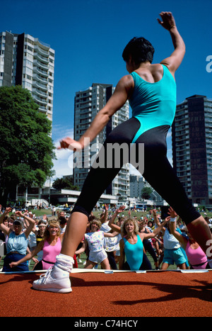 L'exercice de la femme à l'extérieur et à la tête d'un groupe d'adultes en classe l'exercice en plein air, West End, Vancouver, British Columbia, Canada Banque D'Images