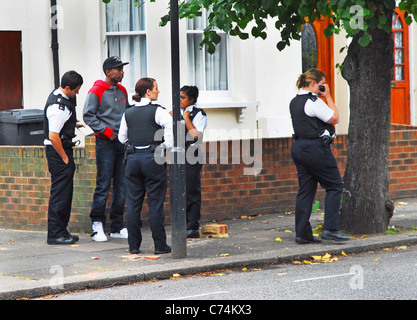 Quatre policiers s'arrêtent et foutent un jeune homme noir dans la rue de Haringey, dans le nord de Londres, après un récent combat de rue. Banque D'Images