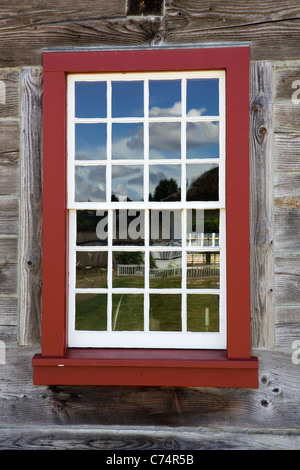 Encadré rouge fenêtre blanche sur un vieux bâtiment en bois bleu ciel réflexion Banque D'Images