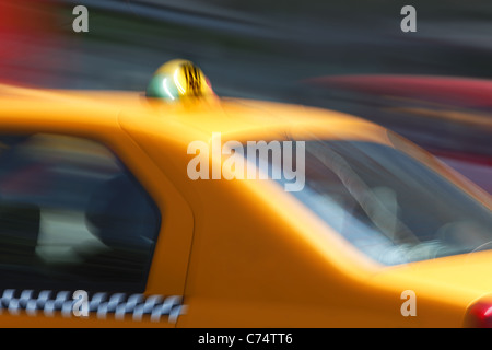Motion blurred et douce image d'un taxi jaune rapide dans la circulation, avec un peu déplacé de détails sur le "taxi" signe sur la voiture. Banque D'Images